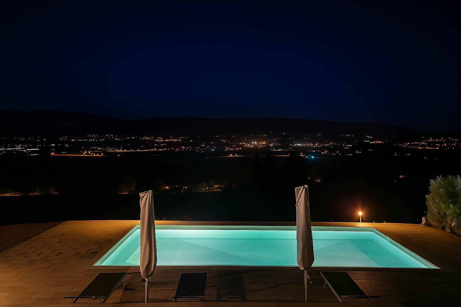Piscine illuminée et panorama nocturne